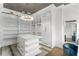 Luxurious walk-in closet with ladder access, island, vanity, and a stunning chandelier for a boutique-style feel at 4807 W Longfellow Ave, Tampa, FL 33629