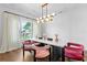 Bright dining room features a modern chandelier, white walls, and a view of the front yard at 4807 W Longfellow Ave, Tampa, FL 33629