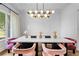 Elegant dining room with wainscoting, a modern chandelier, and pink velvet chairs at 4807 W Longfellow Ave, Tampa, FL 33629