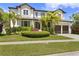Beautiful two-story home with manicured landscaping and a brick driveway with palm trees at 4807 W Longfellow Ave, Tampa, FL 33629