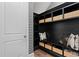 Mud room with black built-in shelving, baskets, and decorative striped wallpaper at 4807 W Longfellow Ave, Tampa, FL 33629