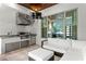 Outdoor kitchen area with stainless steel appliances and comfortable lounge seating with a view at 4807 W Longfellow Ave, Tampa, FL 33629