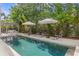 Relaxing backyard pool area with lounge chairs, umbrellas, and lush landscaping at 4807 W Longfellow Ave, Tampa, FL 33629