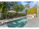 Spacious backyard pool with lounge chairs, umbrellas, and a water feature at 4807 W Longfellow Ave, Tampa, FL 33629