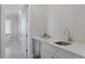 Modern wet bar features marble countertops, a stainless steel sink, and white cabinetry, conveniently located adjacent to the bathroom at 4807 W Longfellow Ave, Tampa, FL 33629