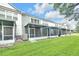 Large backyard featuring a green lawn and screened-in patios, ideal for outdoor relaxation and entertainment at 4910 Chatham Gate Dr, Riverview, FL 33578
