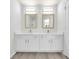 Bright bathroom features a dual sink vanity with modern fixtures, framed mirrors, and contemporary lighting at 4910 Chatham Gate Dr, Riverview, FL 33578