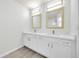 Bright bathroom features a dual sink vanity with modern fixtures, framed mirrors, and contemporary lighting at 4910 Chatham Gate Dr, Riverview, FL 33578