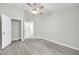 Bedroom showcasing wood-look flooring, ceiling fan, closet, and door leading to other rooms at 4910 Chatham Gate Dr, Riverview, FL 33578