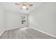 Bright bedroom featuring wood-look flooring, a modern ceiling fan, and natural light from the window at 4910 Chatham Gate Dr, Riverview, FL 33578