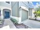 Attached garage and covered entrance with modern blue door and manicured landscaping at 4910 Chatham Gate Dr, Riverview, FL 33578