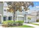 Two-story townhome featuring a two-car garage, covered entry, and mature tree at 4910 Chatham Gate Dr, Riverview, FL 33578