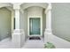 Green front door with sidelights framed by white columns and covered porch at 4910 Chatham Gate Dr, Riverview, FL 33578