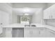 Modern kitchen featuring white quartz countertops, stainless steel appliances and view of dining area at 4910 Chatham Gate Dr, Riverview, FL 33578