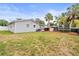 Spacious backyard featuring a trampoline, playhouse, mature palms, and a well-maintained lawn at 512 Flame Tree Dr, Apollo Beach, FL 33572