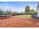 Large backyard with new mulch, a shed, a trampoline, and a dark wood fence at 512 Flame Tree Dr, Apollo Beach, FL 33572