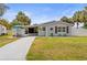Charming single-story home featuring well-maintained landscaping, a long driveway, and cozy front porch at 512 Flame Tree Dr, Apollo Beach, FL 33572
