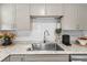 Modern kitchen featuring granite countertops, stainless steel sink, and white subway tile backsplash at 512 Flame Tree Dr, Apollo Beach, FL 33572