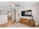 Comfortable living room with wood flooring, a large TV, and adjacent kitchen area at 512 Flame Tree Dr, Apollo Beach, FL 33572