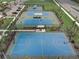 Aerial view of community tennis and basketball courts, surrounded by trees and landscaping at 6118 Voyagers Pl, Apollo Beach, FL 33572