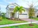 Charming two-story home featuring a well-maintained lawn, a brick driveway, and a welcoming entrance at 6118 Voyagers Pl, Apollo Beach, FL 33572