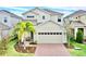 Traditional two-story home with a two-car garage, driveway, and a palm tree at 6118 Voyagers Pl, Apollo Beach, FL 33572