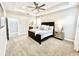 Comfortable main bedroom shows trey ceilings, ceiling fan, with access to the main bathroom at 6118 Voyagers Pl, Apollo Beach, FL 33572