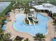 Aerial view of a community pool with water slides, lounge chairs, and lush landscaping at 6118 Voyagers Pl, Apollo Beach, FL 33572