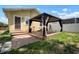 Backyard featuring a wooden deck with a gazebo and an adjacent yellow house with stairs leading to a glass panel door at 6419 S Englewood Ave, Tampa, FL 33611