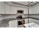 Modern kitchen with stainless steel appliances, white cabinets, and decorative backsplash at 644 Yardarm Dr # 22, Apollo Beach, FL 33572