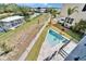 Aerial view of a backyard featuring a pool, a white picket fence, and lush landscaping at 6520 Simone Shores Cir, Apollo Beach, FL 33572