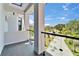 Balcony with glass railings provides a scenic view of the neighborhood's street and lush palm trees at 6520 Simone Shores Cir, Apollo Beach, FL 33572