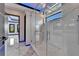 Modern bathroom with a large glass shower enclosure, marble flooring, and an open doorway at 6520 Simone Shores Cir, Apollo Beach, FL 33572