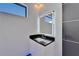 Modern bathroom features a vanity with an illuminated mirror, black countertop, and window at 6520 Simone Shores Cir, Apollo Beach, FL 33572