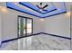 Modern bedroom with sliding glass doors to a balcony and ambient ceiling lighting for a relaxing atmosphere at 6520 Simone Shores Cir, Apollo Beach, FL 33572