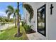 Exterior detail of a modern home, showing a side door and palm trees at 6520 Simone Shores Cir, Apollo Beach, FL 33572