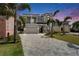 Beautiful home with lush palm trees, a large driveway, and a manicured lawn creating a welcoming curb appeal at 6520 Simone Shores Cir, Apollo Beach, FL 33572