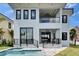 Rear of a modern two-story home with a balcony and covered outdoor patio at 6520 Simone Shores Cir, Apollo Beach, FL 33572