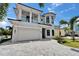 Beautiful home with lush palm trees, a large driveway, and a manicured lawn creating a welcoming curb appeal at 6520 Simone Shores Cir, Apollo Beach, FL 33572