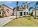 Beautiful home with lush palm trees, a large driveway, and a manicured lawn creating a welcoming curb appeal at 6520 Simone Shores Cir, Apollo Beach, FL 33572