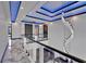Grand foyer with marble floors, glass railings, and a modern chandelier highlighting the home's soaring ceilings at 6520 Simone Shores Cir, Apollo Beach, FL 33572