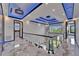 Elegant foyer with marble floors, glass railings, and spiral staircase leading to the lower level at 6520 Simone Shores Cir, Apollo Beach, FL 33572