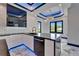 Modern kitchen boasts marble floors, island, stainless appliances, unique backsplash and blue LED lighting at 6520 Simone Shores Cir, Apollo Beach, FL 33572