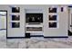 Modern living room has built-in shelving and electric fireplace with blue LED lighting at 6520 Simone Shores Cir, Apollo Beach, FL 33572
