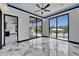 Bright living room with marble floors and multiple sliding glass doors opening to the outdoor patio and pool at 6520 Simone Shores Cir, Apollo Beach, FL 33572