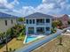 An exterior of a two-story home with a pool in the backyard and a partial view of the neighboring home at 6520 Simone Shores Cir, Apollo Beach, FL 33572