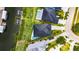 Aerial view showcasing a modern home, lush landscaping, private pool, and waterfront access at 6526 Simone Shores Cir, Apollo Beach, FL 33572