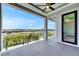 Balcony with clear glass railings offers panoramic views of the lush landscape and blue skies at 6526 Simone Shores Cir, Apollo Beach, FL 33572