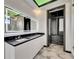 Modern bathroom features a sleek double sink vanity with marble floors and an open closet at 6526 Simone Shores Cir, Apollo Beach, FL 33572