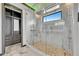 This bathroom showcases a large glass shower with river rock flooring and marble tile walls at 6526 Simone Shores Cir, Apollo Beach, FL 33572